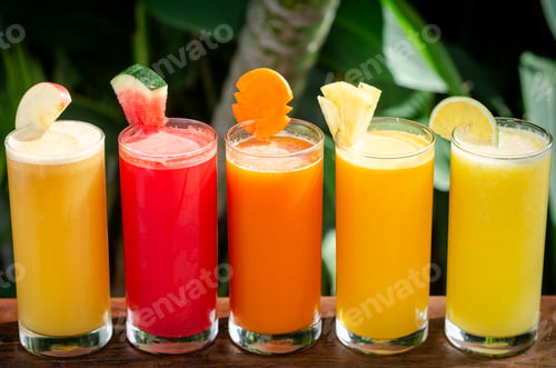 Preview: mixed fresh organic fruit juices glasses on sunny garden table