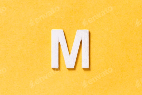 Preview: Letter M of the alphabet isolated on yellow background, top view