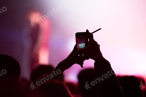 Preview: Silhouette of hands recording a concert with smart phones. Crowd of people using smart phones