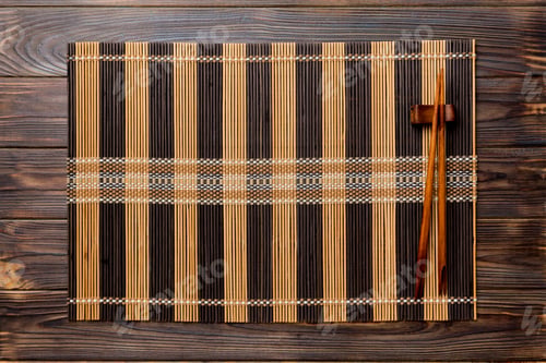 Preview: Two chopsticks and bamboo mat on wooden background. Top view, copy space