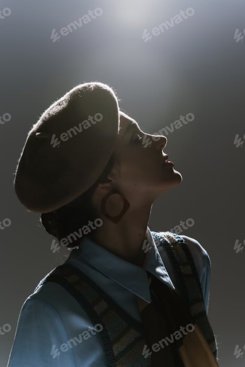 Preview: silhouette of pretty young woman in beret and autumnal outfit on dark grey background