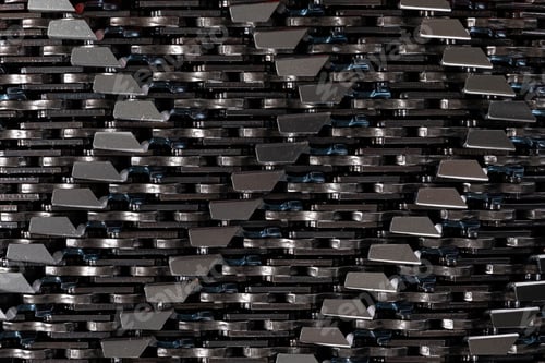Preview: Close-up photo of grey metal saw chain. Background of sawchains