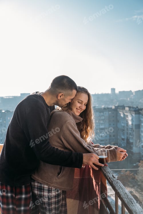 Preview: Affectionate Couple Embracing on Balcony with City View