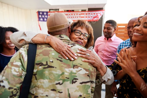 Preview: Millennial black soldier returning home to his family, embracing grandmother, back view