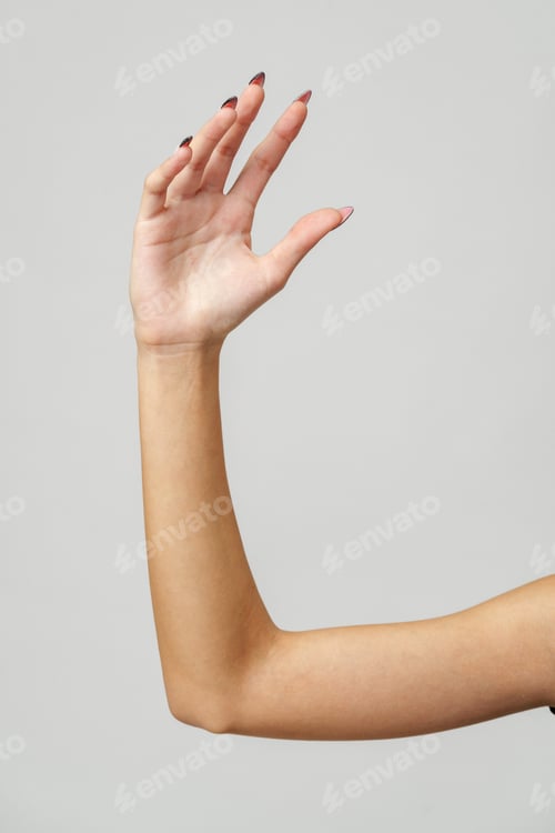 Preview: Woman's Arm Extended With Hand Open and Fingers Against a White Background