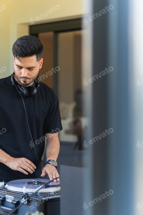 Preview: Portrait of a young dj playing mixing disc during a music event