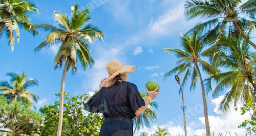 Preview: Girl on the beach drinks coconut. Selective focus.