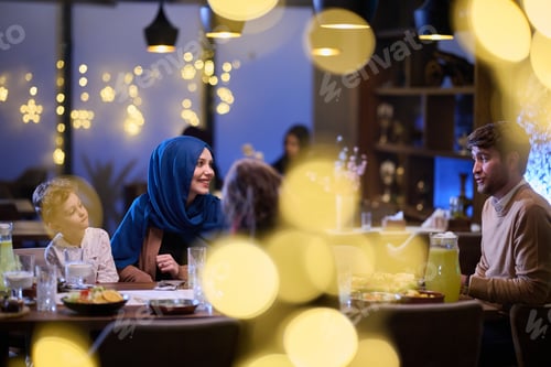 Preview: In a modern restaurant, an Islamic couple and their children joyfully await their iftar meal during