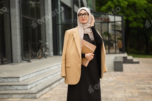 Preview: modern stylish muslim woman in hijab in city street