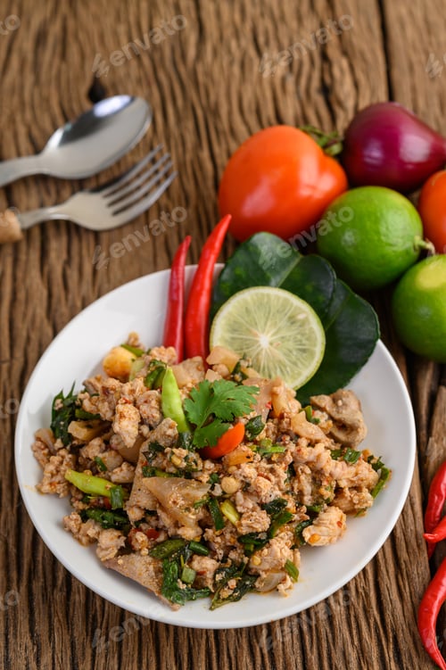 Preview: Spicy Minced Pork Salad on a white plate on wooden table.