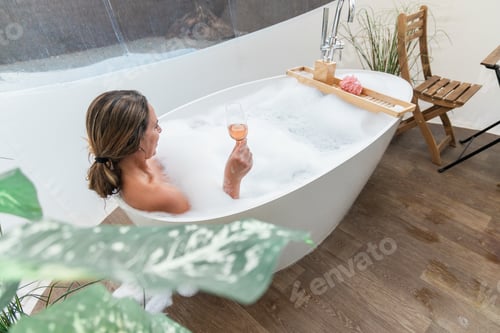 Preview: Woman enjoying wine in bathtub