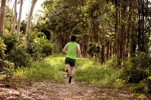 Preview: Woman trail runner running at tropical forest mountain peak