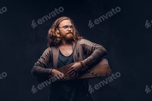 Preview: Redhead hipster male playing on a Russian traditional musical instrument - gusli