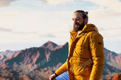 Preview: Traveler stands alone at the edge of a towering mountain range