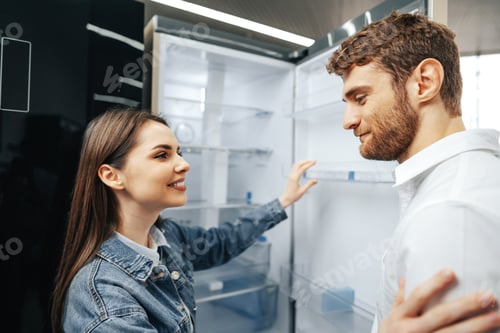 Preview: Young couple selecting new refrigerator in household appliance store