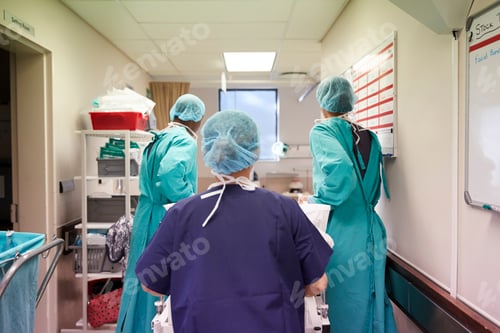 Preview: Surgical Team Wheeling Senior Male Patient Out Of Hospital Operating Theatre