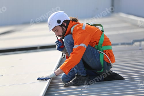 Preview: Professional worker installing solar panels on the roof of a house.
