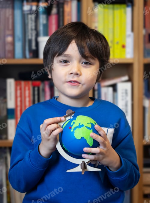 Preview: Portrait kid happy face holding globe sitting at library, Child boy learning about Geography