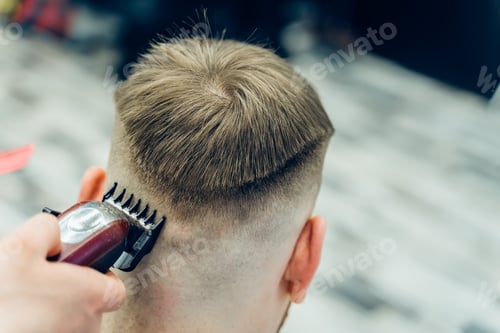 Preview: Barber makes haircut for client at the barber shop by using hairclipper.