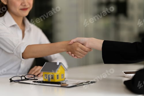 Preview: Real estate broker and customer shaking hands after signing a contract: real estate, home loan and