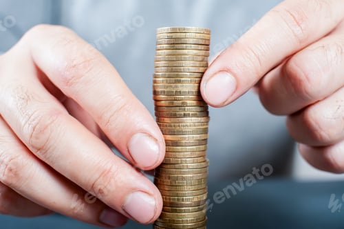 Preview: A man stacks coins in a close-up. Economy concept