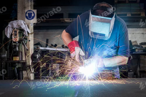 Preview: Man Welding With Protective Gear in an Urban Setting