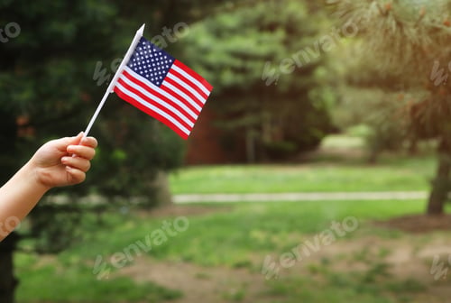 Preview: Beautiful american flag in her hand laughing on sunny day Independence Day, Flag Day concept