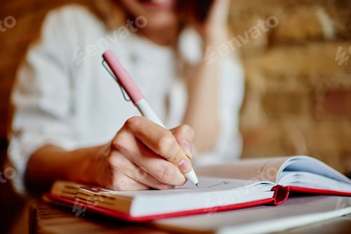 Preview: Woman talking on smartphone and taking notes