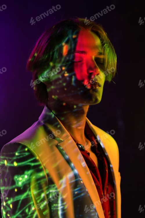 Preview: Androgynous man with closed eyes under bright light