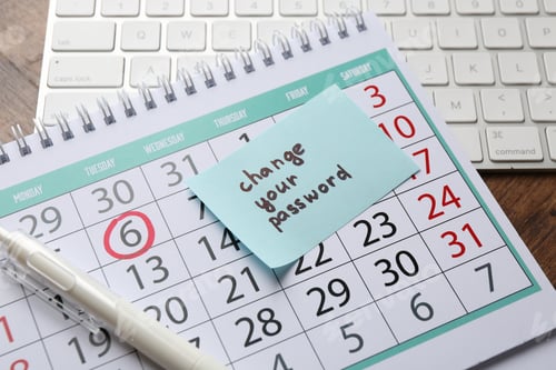 Preview: Note with phrase Change your password, calendar, pen and keyboard on wooden desk, closeup