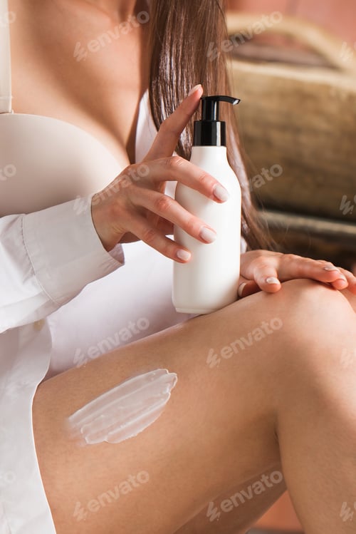 Preview: a moisturizer on a woman's leg, in the other hand she holds a dispenser with cosmetics.