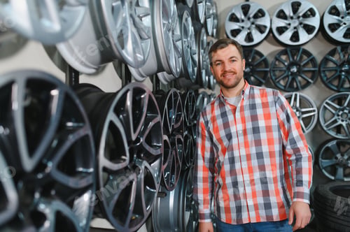 Preview: Portrait of tire technician selling new aluminum car rims