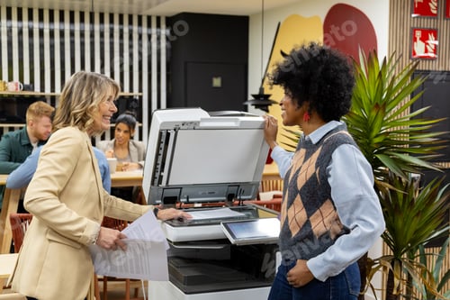 Preview: Diverse women collaborating on office photocopier