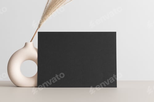 Preview: Black invitation card mockup with a reed pampas on the beige table. 5x7 ratio, similar to A6, A5.