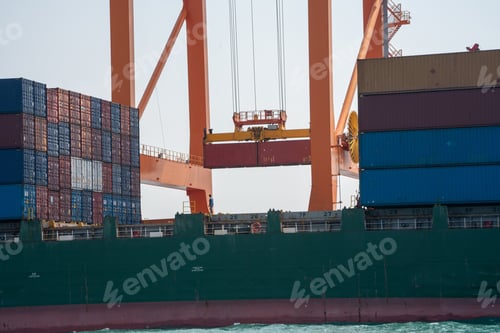 Preview: crane loading cargo container from truck to container ship in the international terminal