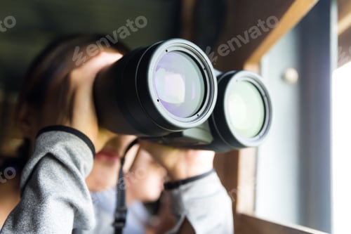Preview: Asian Young woman use of the binocular for watching bird