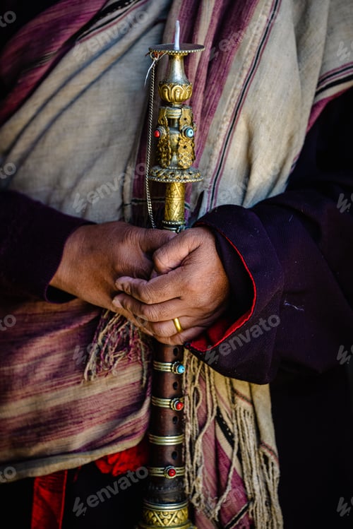 Preview: Vertical shot of the hands holding a golden ancient ritual horn at Tiji festival