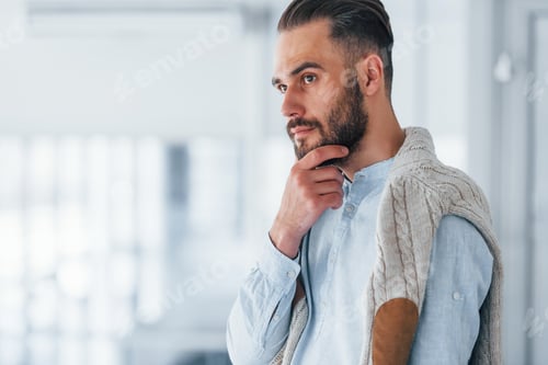 Preview: Young handsome man in formal clothes indoors in the office at daytime