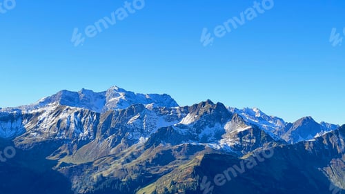 Preview: Scenic view of rocky mountains covered with snow against a blue sky