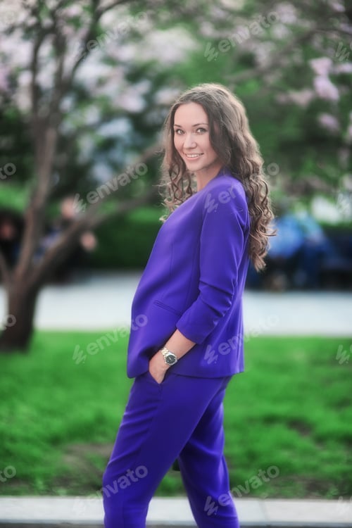 Preview: Business woman in a purple trouser suit on a city street