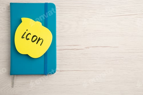 Preview: top view icon written on sticky note on blue notepad on table with free space