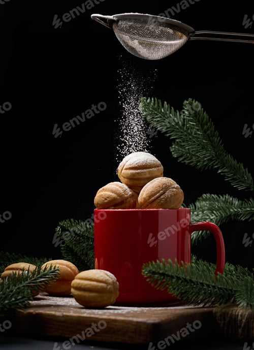 Preview: baked dessert in the shape of a nut in a red ceramic mug. Powdered sugar is poured on top