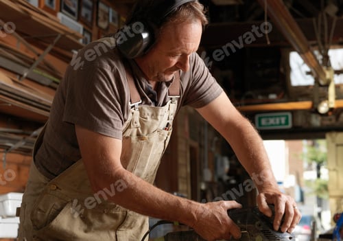 Preview: Boat builder sanding wood in workshop
