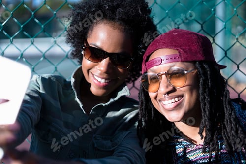 Preview: Female friends taking self portrait using smartphone