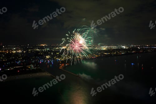 Visualização: Vista aérea de fogos de artifício brilhantes explodindo com luzes coloridas sobre a costa do mar