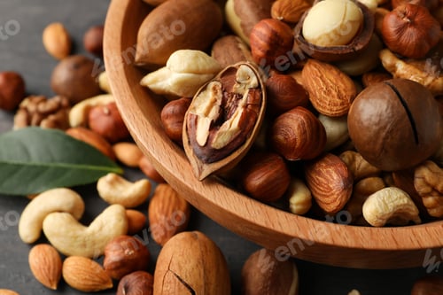 Preview: Wood bowl with different tasty nuts on gray wooden background