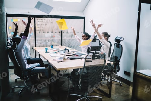 Preview: Diverse satisfied entrepreneurs rejoicing in success during meeting in office