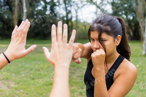Preview: Female boxer training boxing sparring and punching outdoors