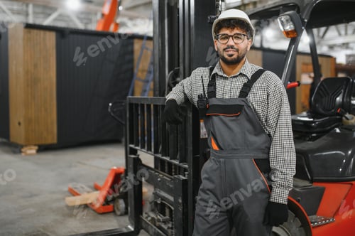 Preview: Arab forklift operator leaning on machine in modular house factory