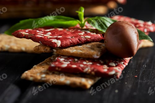 Preview: Beetroot and rye flour crackers with vegetables for making snacks on a black background.